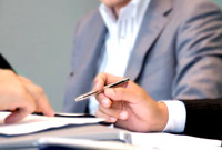 机を挟んで話し合う二人